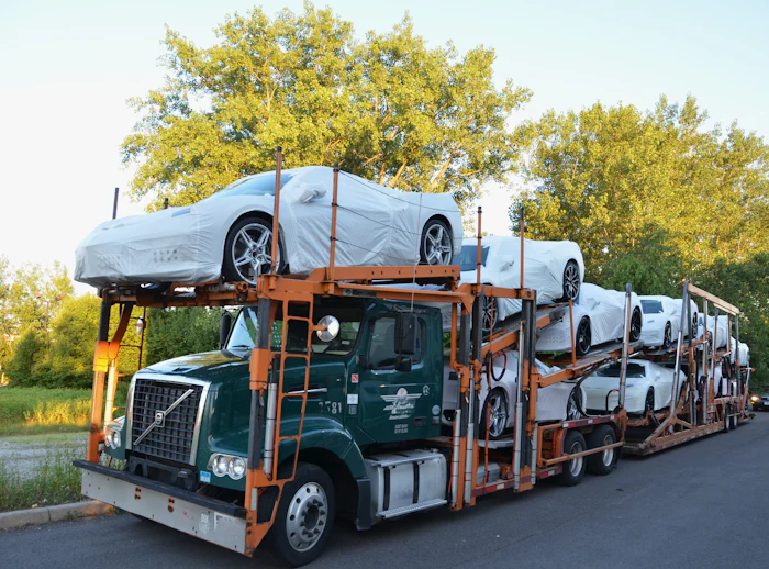 NIKI Hawaii to Texas: Covered vehicles secured on an open auto transport carrier Covered vehicles secured on an open auto transport carrier — NIKI Hawaii to Texas shipping guide