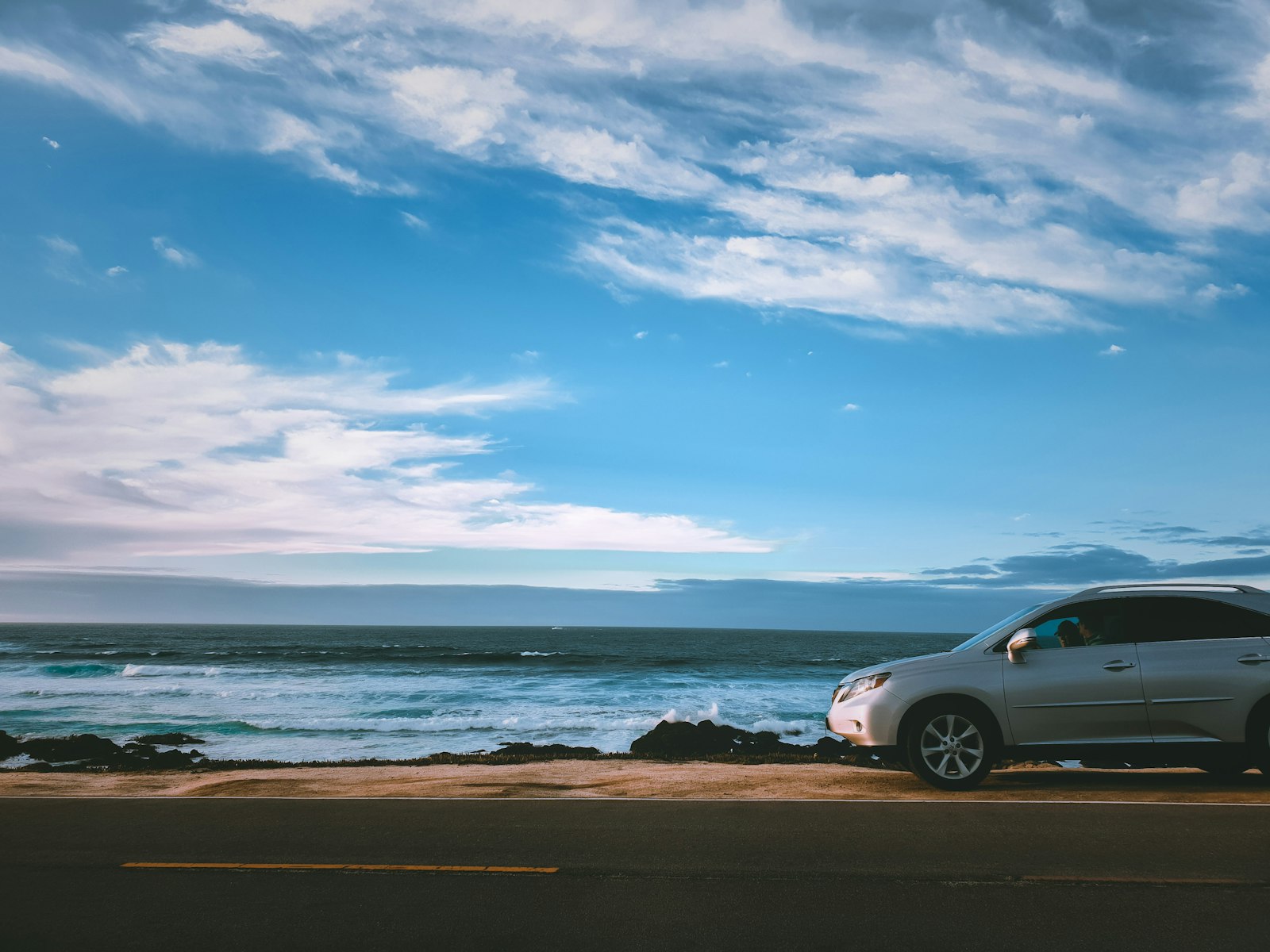 Car parked by the Pacific coast on 17-Mile Drive in California