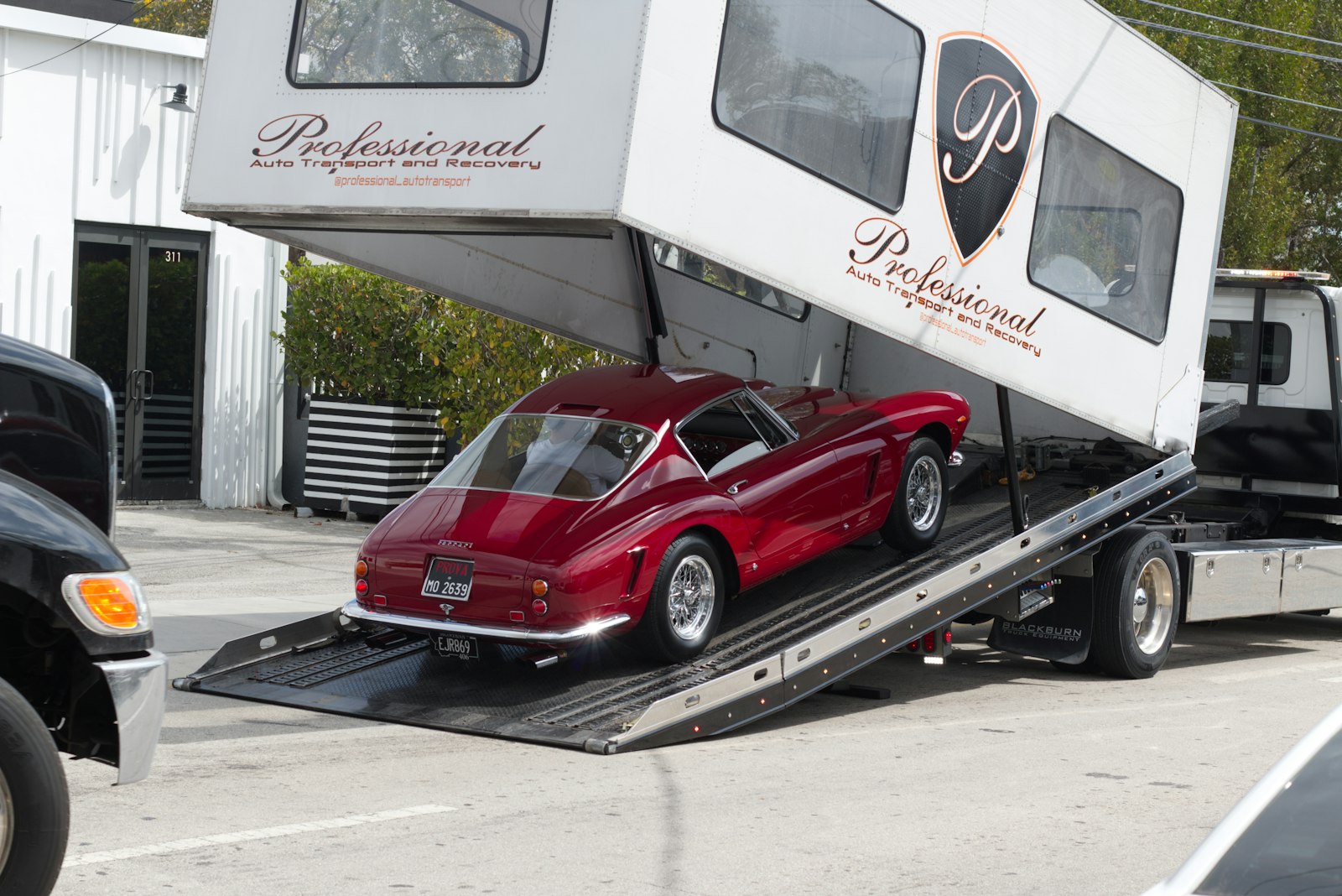 Vintage car being loaded onto a car hauler with ramps